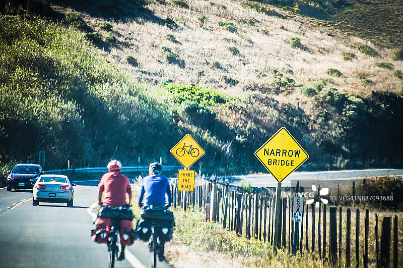 骑行者在加利福尼亚州Point Arena外的1号公路上与汽车同行图片素材