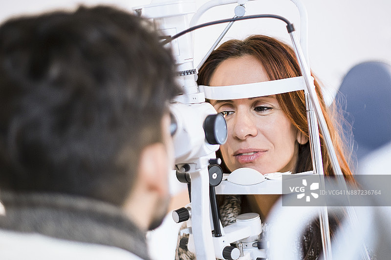 年轻女医生为年轻女子检查眼睛。图片素材