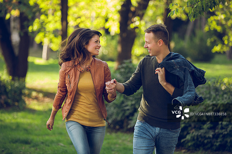 在秋季公园奔跑的情侣图片素材