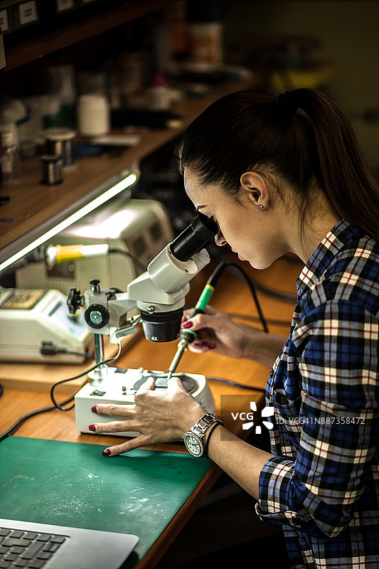 女人在科技办公室焊接电路板图片素材