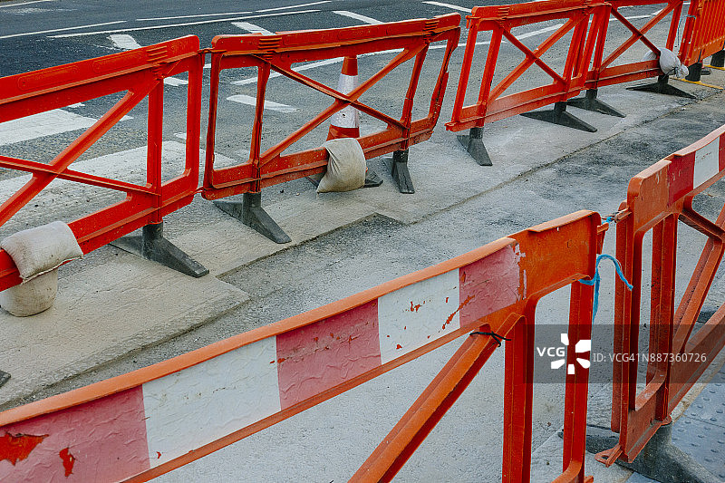城市道路施工现场的红色塑料围栏和沙袋图片素材