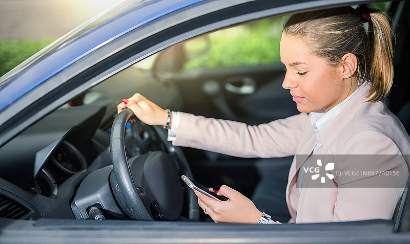 年轻女子开车时发短信图片素材