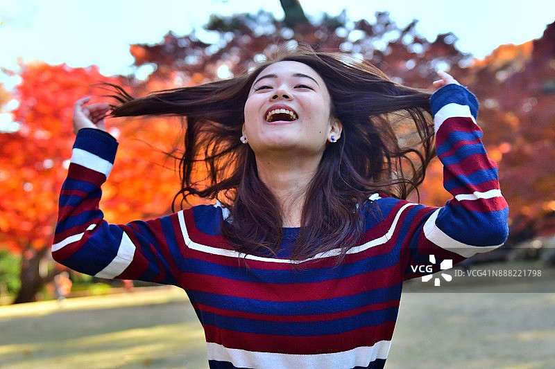 在东京公园玩长发的年轻日本女子图片素材