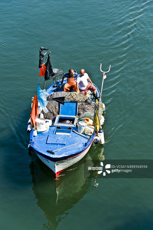 那不勒斯海湾里的小船上的两个渔夫图片素材