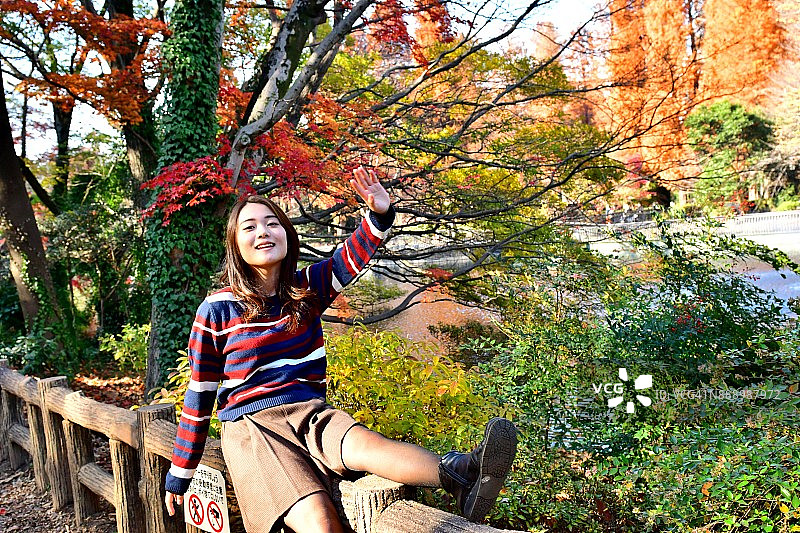 在井之头公园欣赏秋色的年轻日本女人图片素材