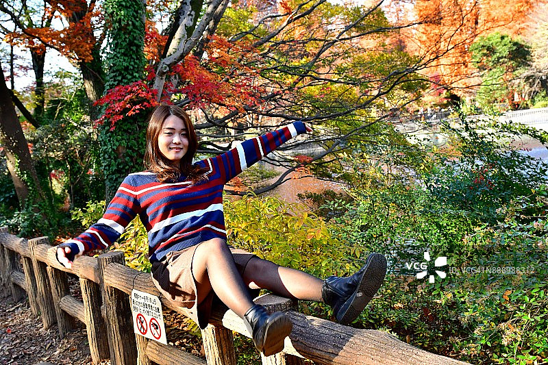 在井之头公园欣赏秋色的年轻日本女人图片素材