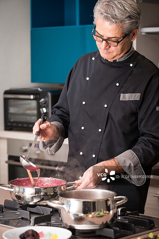 专业厨师在私人住宅准备餐点：准备红菜头烩饭并倒入肉汤图片素材