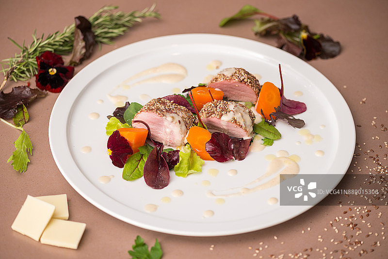 专业厨师在私人住宅准备餐点：配有芝麻、辣根和白巧克力酱的烤猪肉图片素材