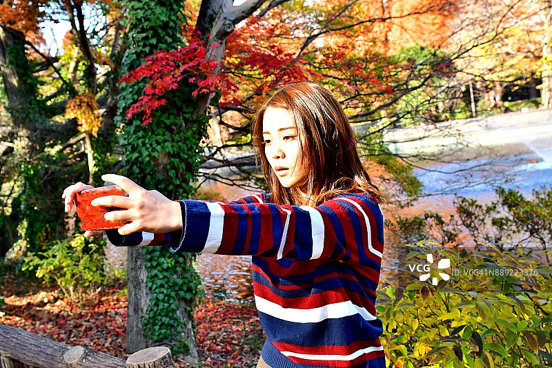 在井之头公园拍摄秋色的年轻日本女人图片素材