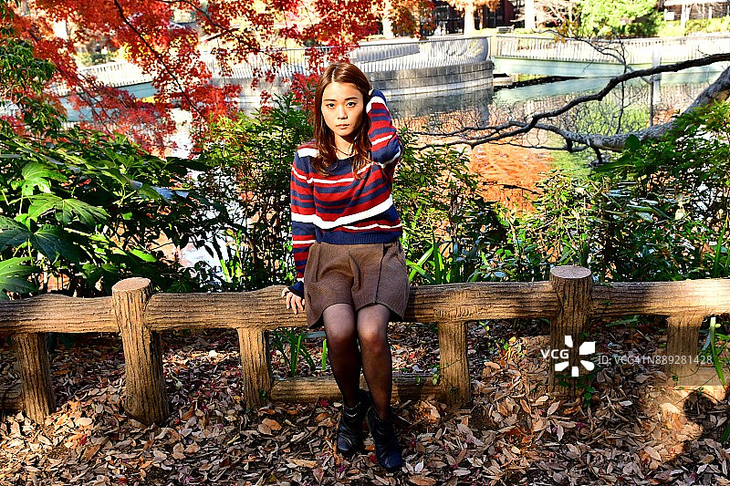 在公园里做各种面部表情的年轻日本女人图片素材