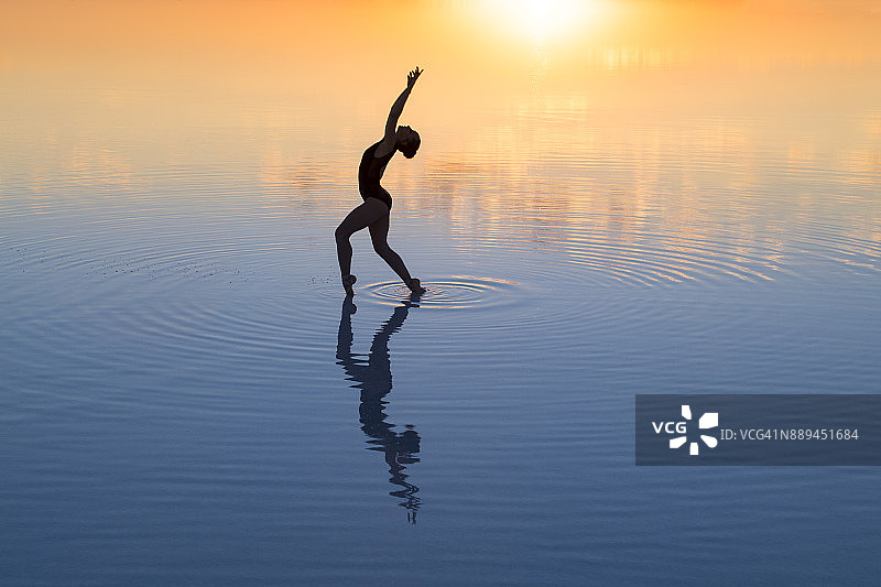 傍晚在湖上跳芭蕾舞的年轻舞者图片素材