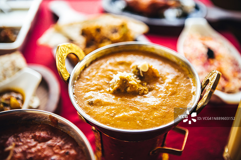 印度美食：黄油鸡肉、唐杜里烤鸡、咖喱羊肉、蔬菜咖喱、萨莫萨三角饺、印度蔬菜饼、巴基斯坦蔬菜饼、馕和印度香米图片素材
