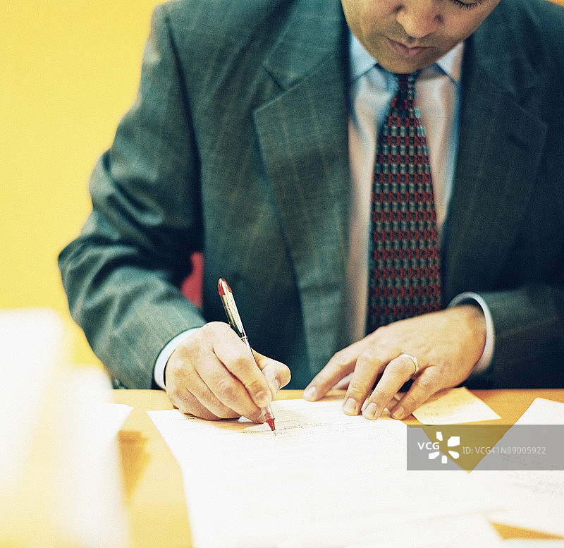办公桌前写作的商人图片素材