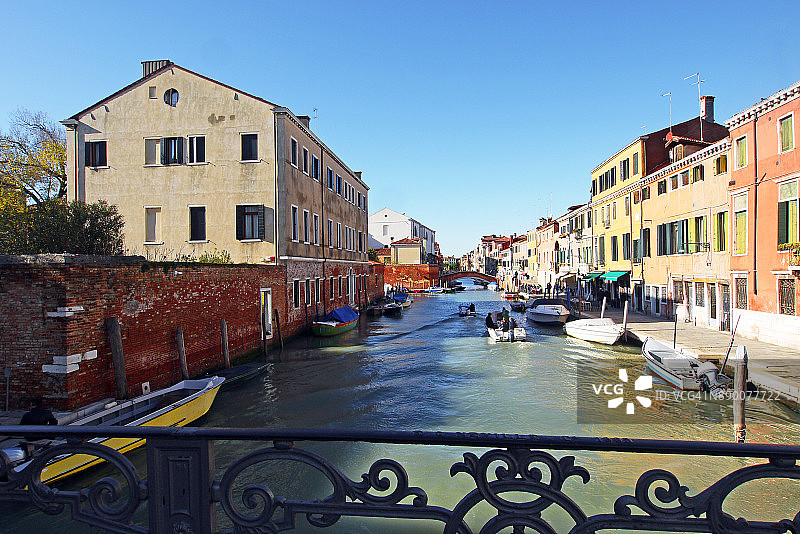 威尼斯运河与系泊船只和桥梁栏杆图片素材