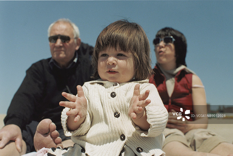 与外祖父和母亲在海滩上的女孩图片素材