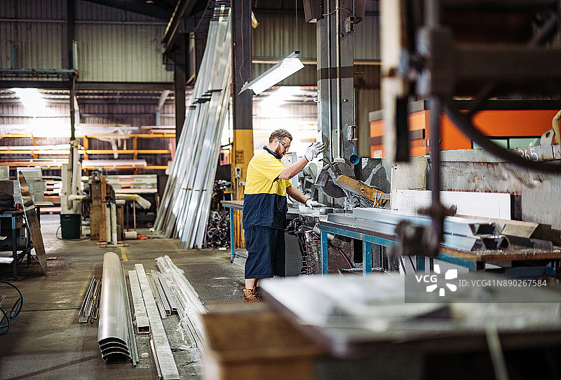 经验丰富的工人在澳大利亚的工厂里操作锯子图片素材