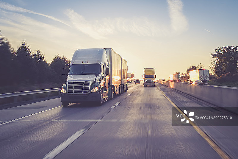 高速公路上日出时的半挂卡车图片素材