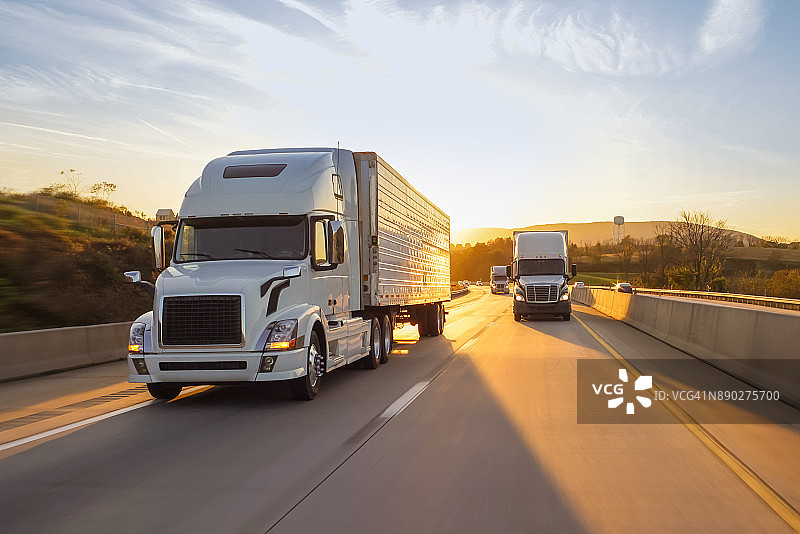 高速公路上日出时的半挂卡车图片素材