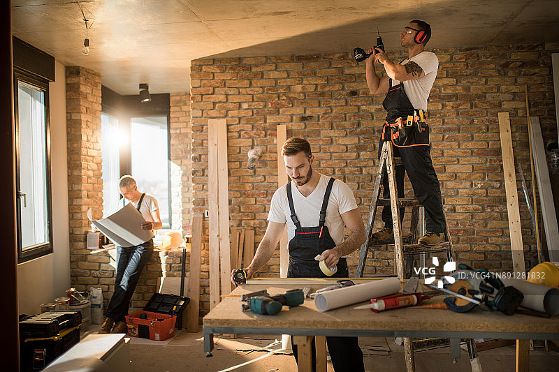 忙碌的建筑工人在公寓里进行家居装修图片素材