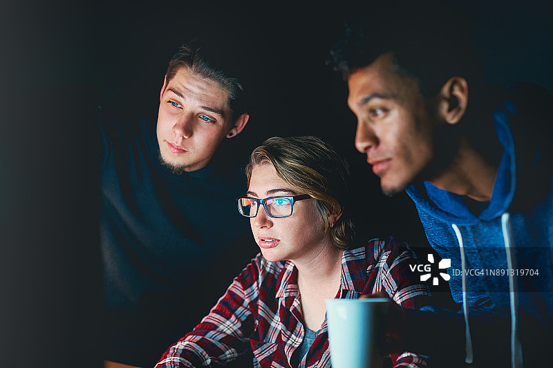 三个年轻人晚上学习电脑图片素材