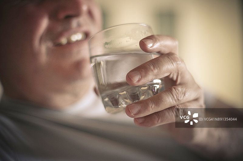 年长的男人拿着玻璃杯图片素材