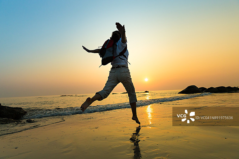 在海滩上背着背包的快乐女人图片素材