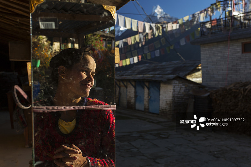 传统房屋庭院里的美丽老妇人图片素材