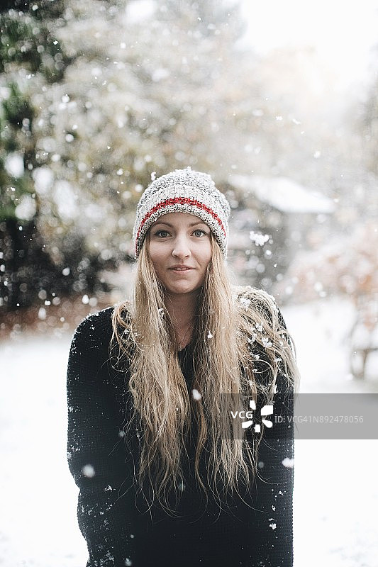 在雪地里戴着羊毛帽的年轻女人图片素材