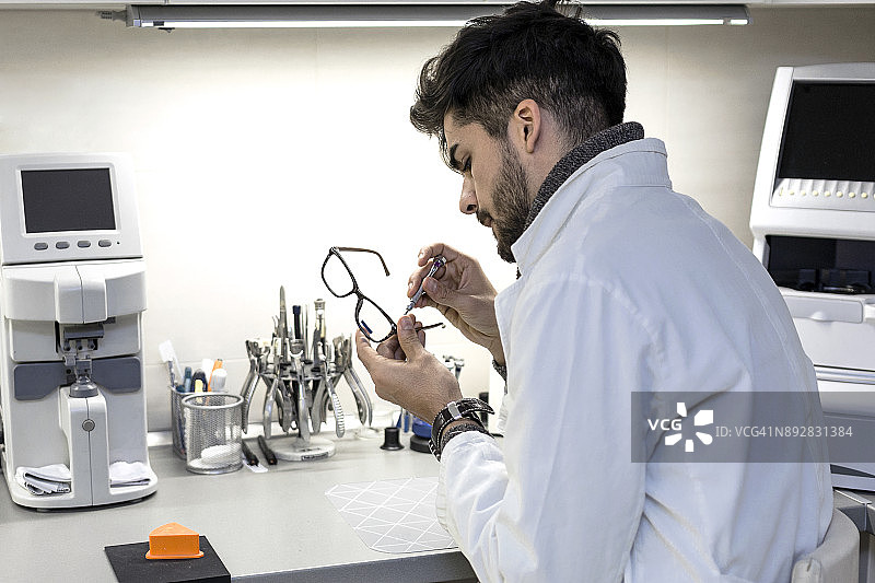 验光师在车间修理眼镜图片素材