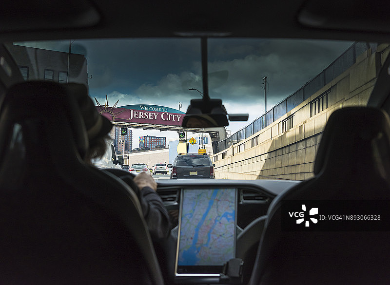 男人驾驶电动汽车驶出荷兰隧道图片素材