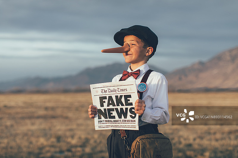 老式匹诺曹报童拿着假报纸图片素材