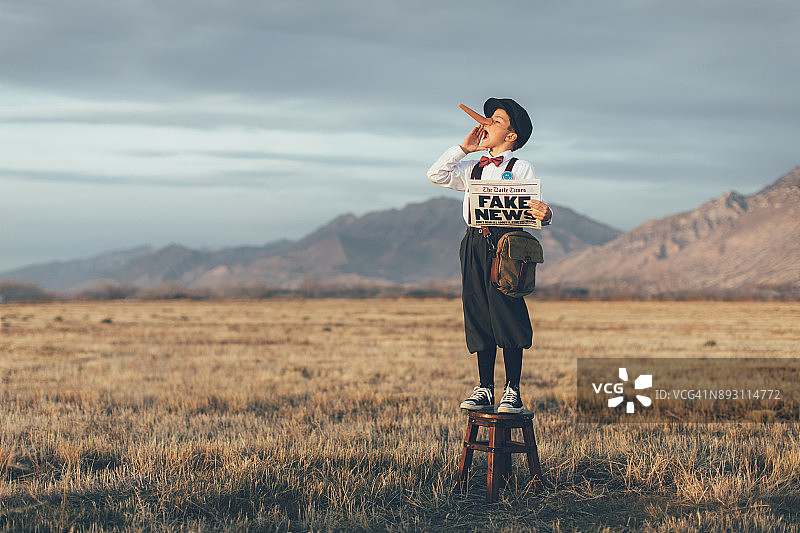 老式匹诺曹报童拿着假报纸图片素材