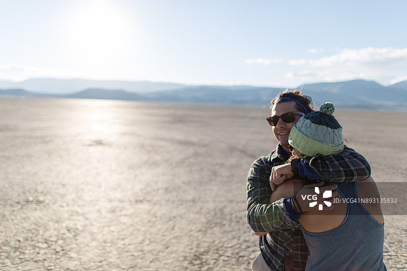 情侣在阳光下拥抱于阿尔沃德沙漠图片素材