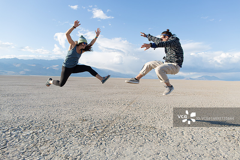 在阿尔沃德沙漠中一起跳跃的情侣图片素材