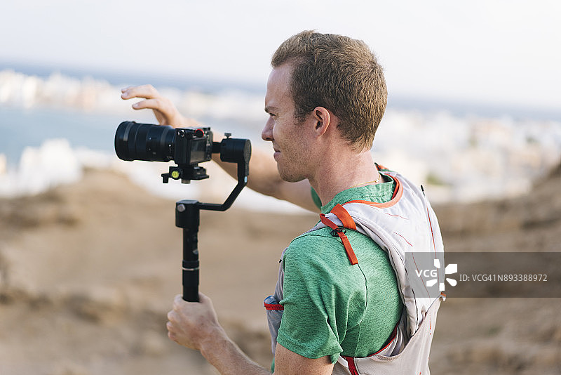 电影制作人手持相机和稳定器拍摄沿海城镇图片素材