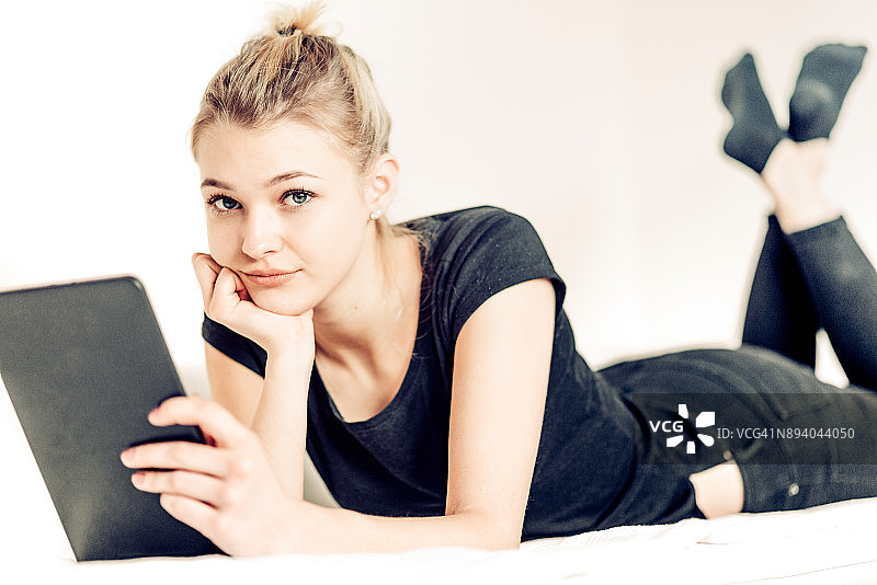 疲惫少女使用平板电脑图片素材