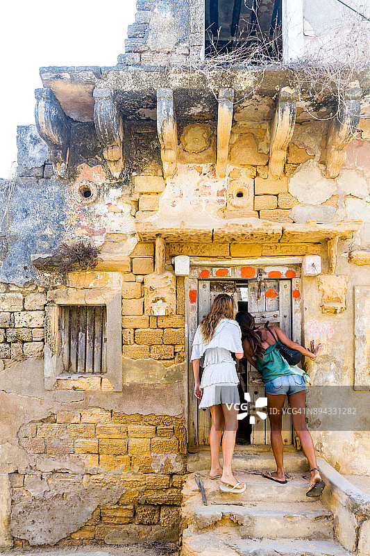 第乌岛上的两位游客与传统建筑图片素材