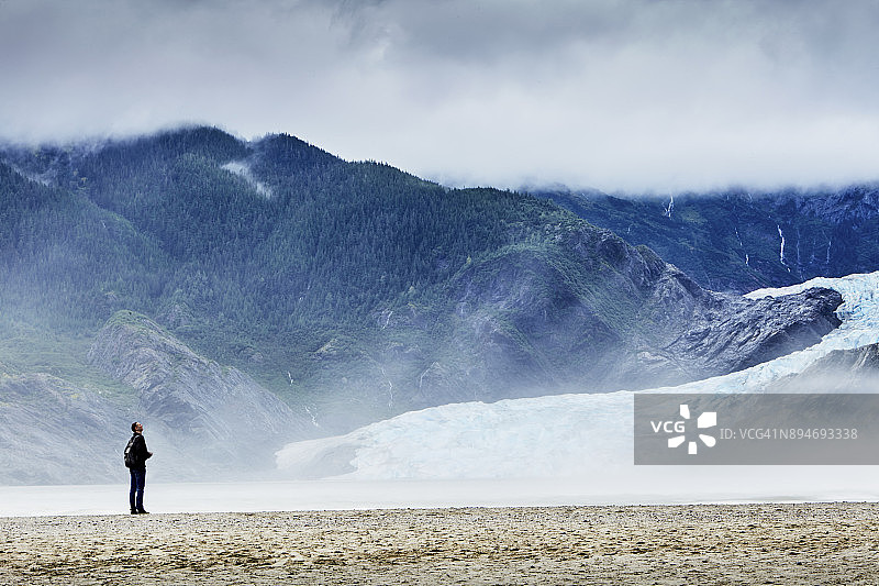男游客在阿拉斯加朱诺的湖泊和冰川旁图片素材