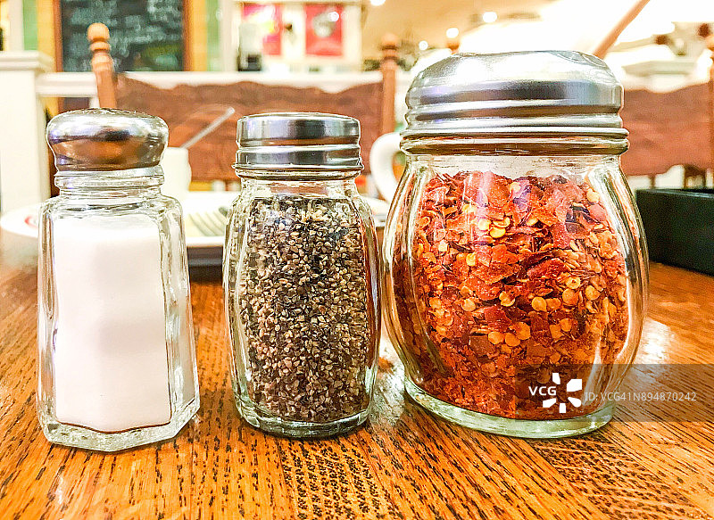 餐厅桌子上的盐、胡椒和辣椒调味瓶图片素材
