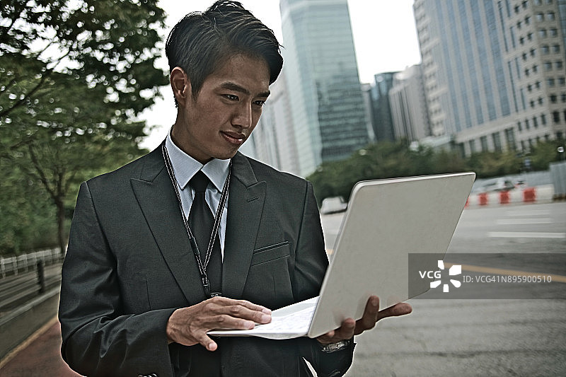 在户外使用笔记本电脑的商人图片素材
