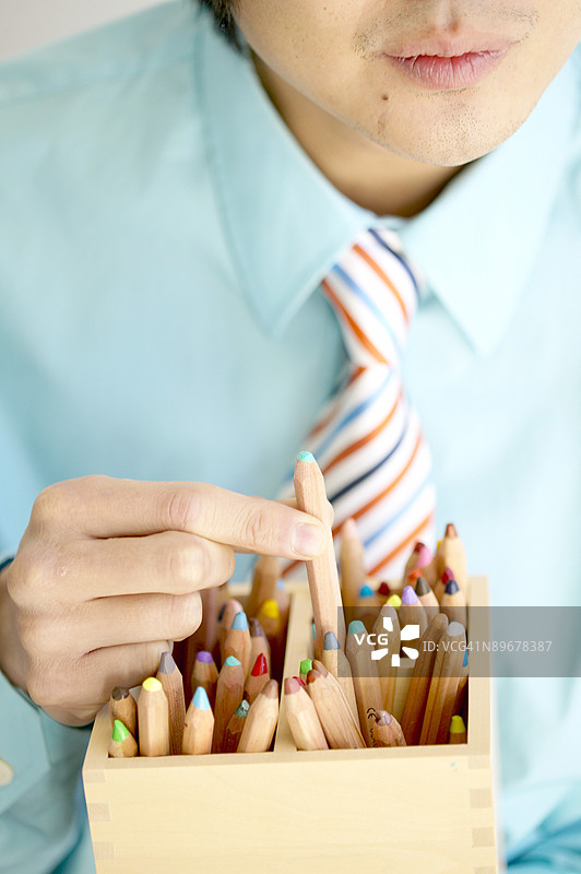 手持彩色铅笔的商人图片素材
