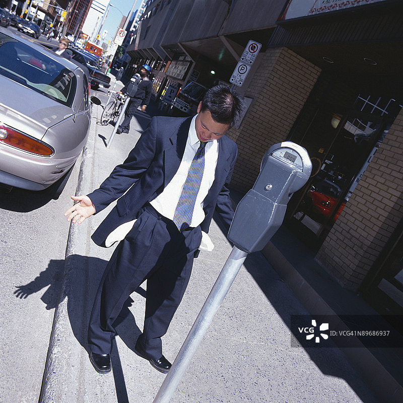 站在停车计时器旁的破产商人图片素材