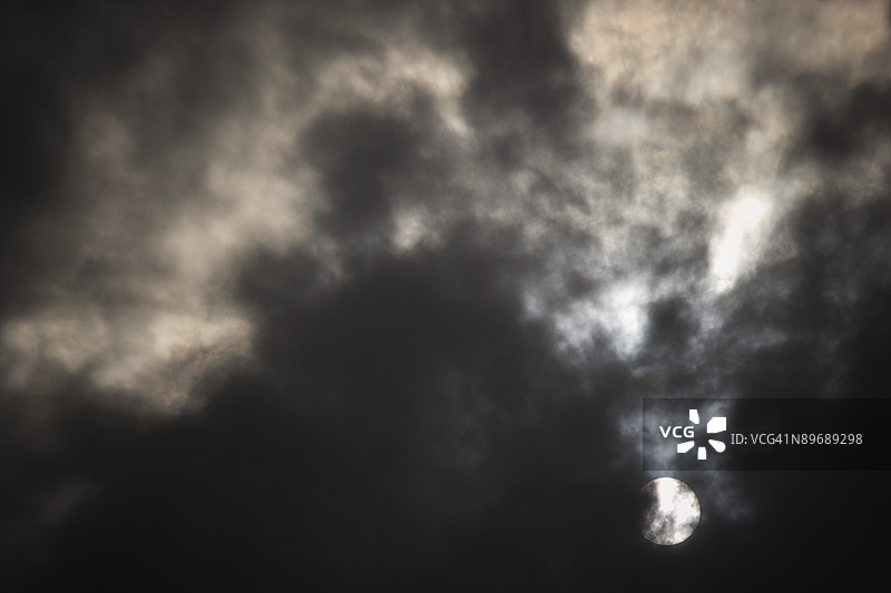 满月照耀在阴暗的多云天空中图片素材