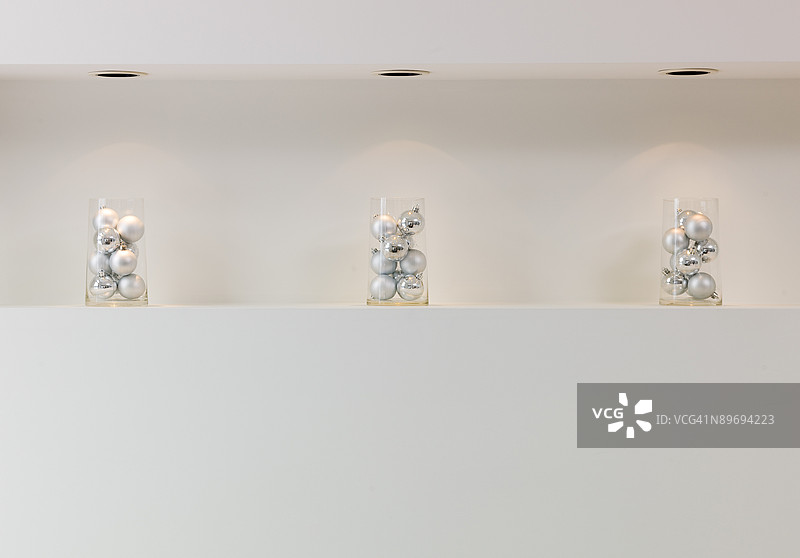 壁炉架上的玻璃容器装饰着银色饰品图片素材