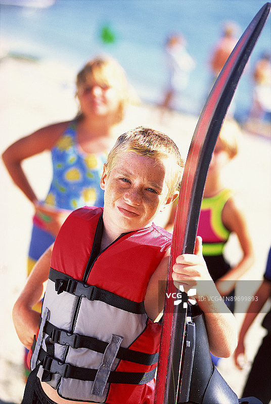 在海滩上穿着救生衣和水橇的男孩图片素材