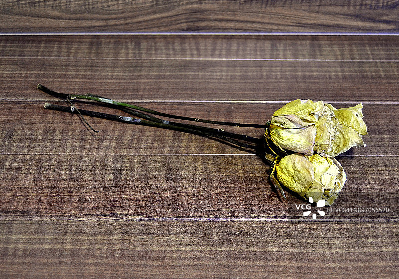 木制背景上的两朵干玫瑰图片素材