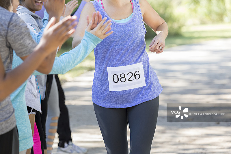 冲过终点线，互相击掌庆祝的女士图片素材