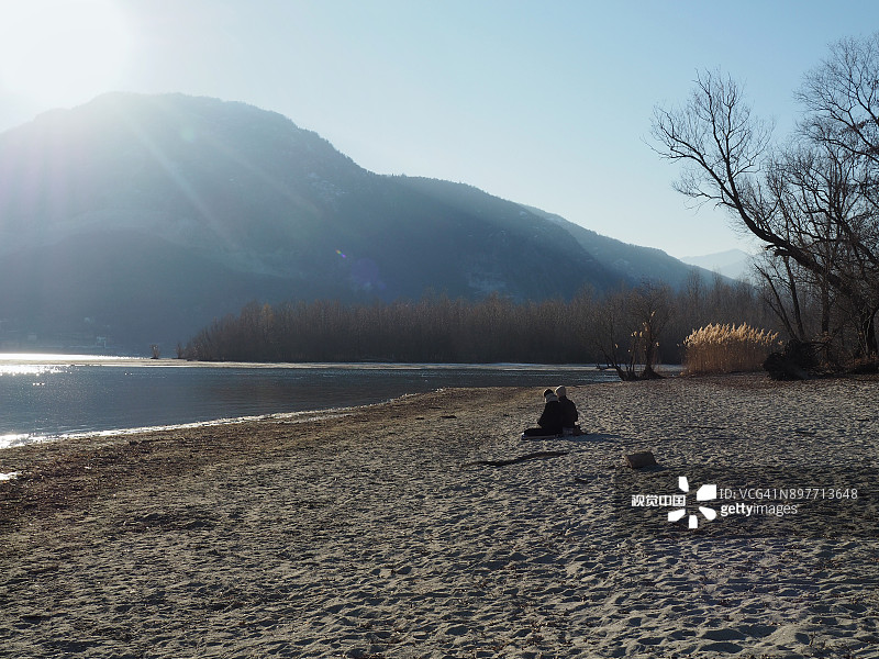 年轻情侣在马焦雷湖海滩上练习瑜伽图片素材