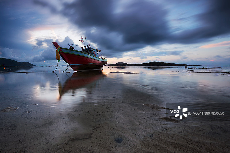 退潮海滩上的传统泰国渔船图片素材