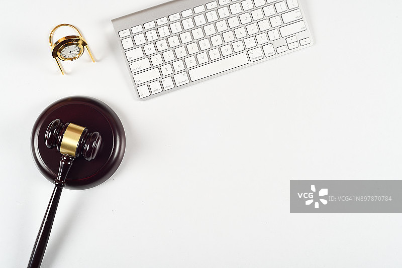 律师工作场所的法律概念，配有电脑键盘、法槌和时钟图片素材